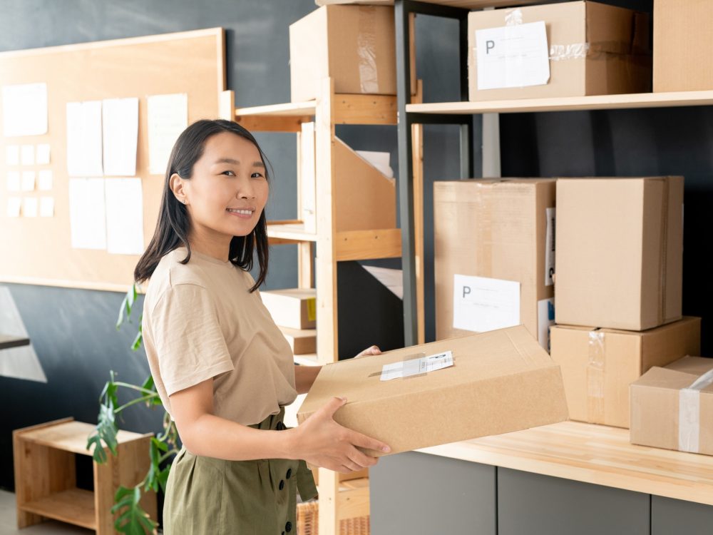 smiling-youngworker-of-post-office-or-storage-room-carrying-order-of-client.jpg